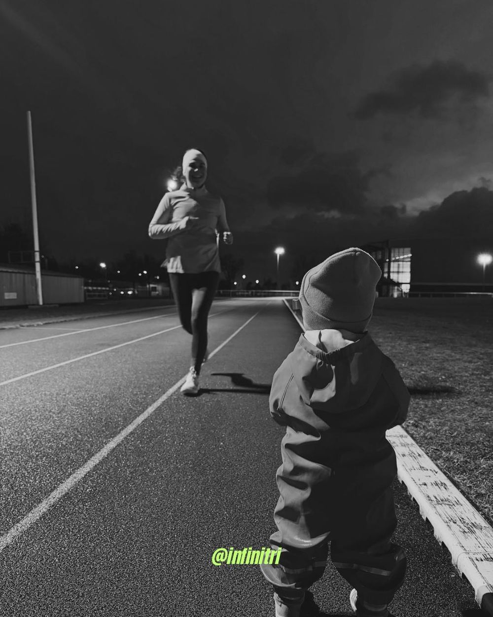 Une adhérente termine son tour de piste à la nuit tombée, son enfant l'attend au bord de la ligne